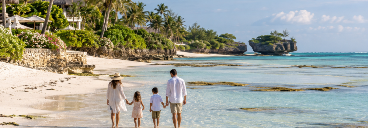 Family walking in shallow water on a beach in Watamu, Kenya