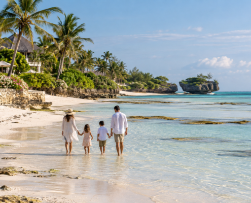 Family walking in shallow water on a beach in Watamu, Kenya