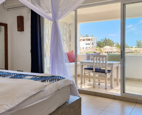 Family Suite bedroom with canopy bed and balcony at Visiwa Beach Resort, Watamu